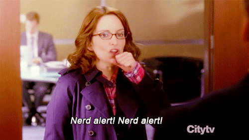 Gif of Tina Fey coughing into hand with caption of "Nerd alert! Nerd alert!"
