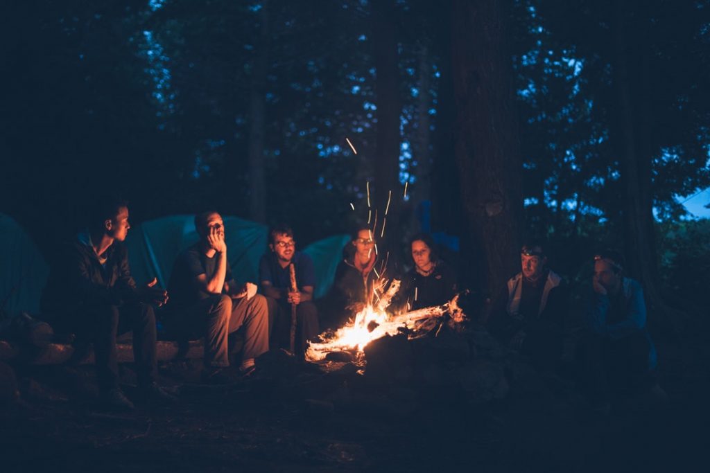 people sitting around a campfire