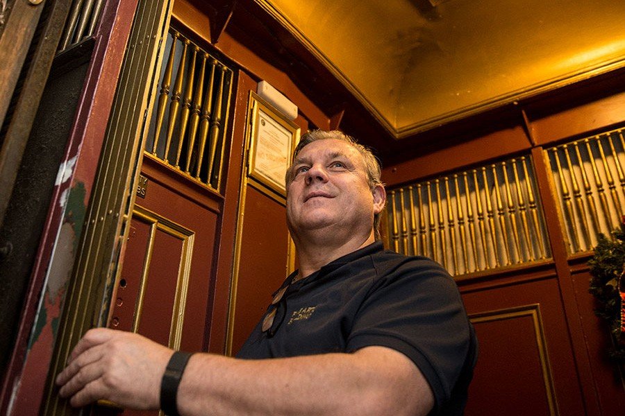 Elevator operator smiling in a manual elevator