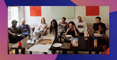 Group photo of Clique employees making silly faces and eating pizza in their office.