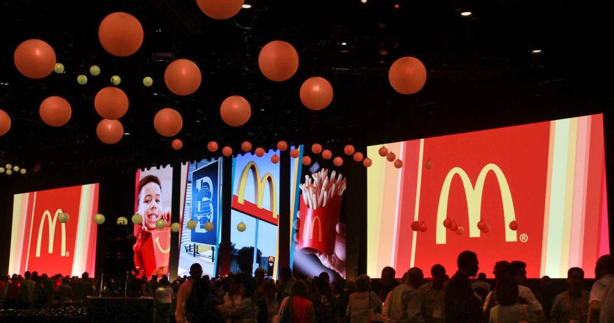 Convention center room for McDonald's event, filled with people