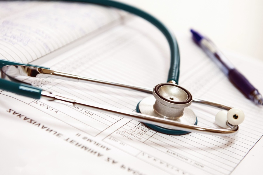 A stethoscope and pen lying on top of a paper chart