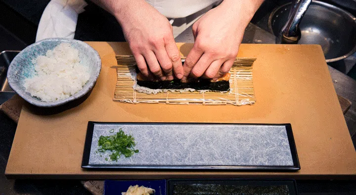 GIF of man making sushi roll