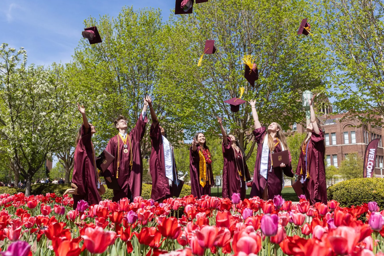 Picture of graduating college students throwing their caps.